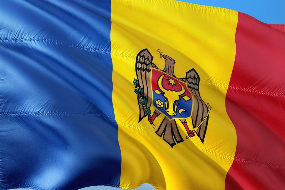 Flag of the country of Moldova, with three colors, blue, yellow, and red from left to right, and the moldovan country crest in the middle, across the yellow section.